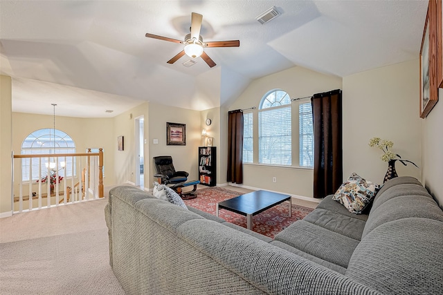 living room featuring a wealth of natural light, visible vents, lofted ceiling, and carpet flooring