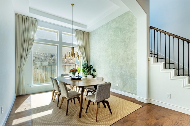 dining area with a wealth of natural light, stairway, a notable chandelier, and wood finished floors