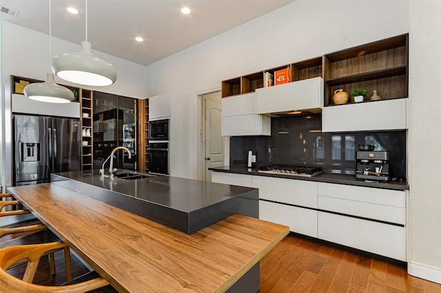 kitchen featuring premium range hood, modern cabinets, a sink, open shelves, and appliances with stainless steel finishes