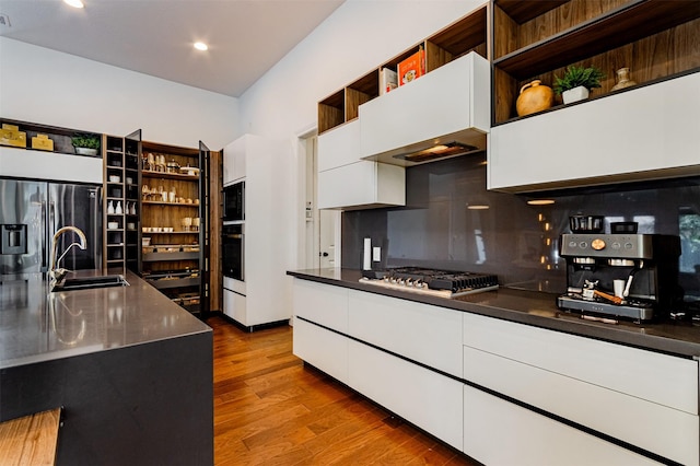 kitchen with modern cabinets, open shelves, gas stovetop, and a sink