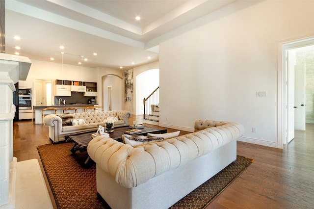 living room featuring recessed lighting, stairway, arched walkways, and wood finished floors