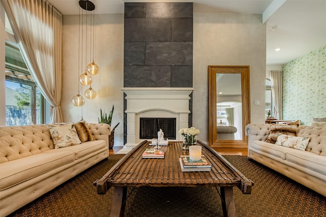 living area featuring wallpapered walls and a fireplace with raised hearth