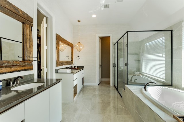 bathroom featuring two vanities, a shower stall, a garden tub, and a sink