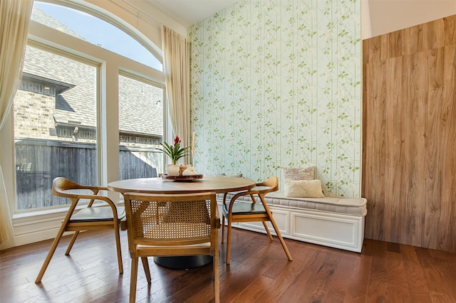 dining space with wallpapered walls, dark wood-style flooring, and breakfast area