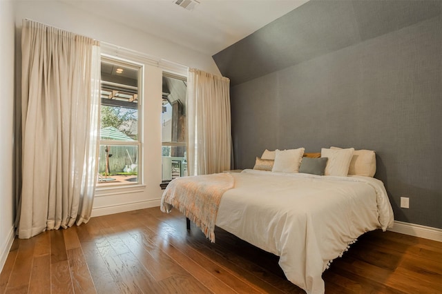 bedroom featuring vaulted ceiling, baseboards, and wood-type flooring