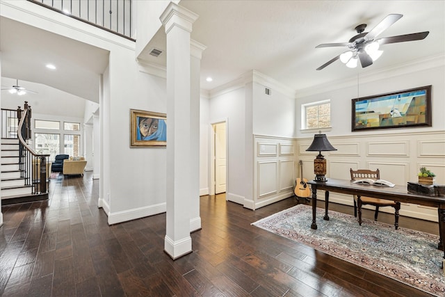 interior space with decorative columns, visible vents, ornamental molding, a ceiling fan, and hardwood / wood-style floors