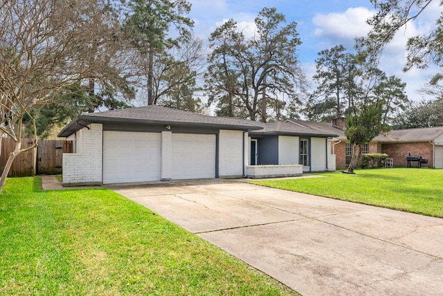 view of front facade featuring a front yard, brick siding, fence, and an attached garage