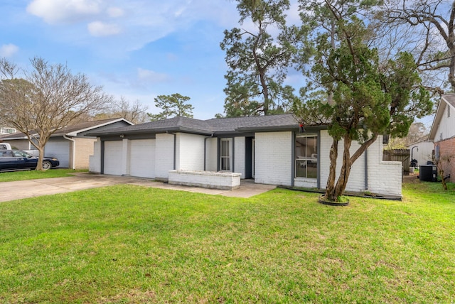 view of front of property with a front lawn, concrete driveway, central AC, and an attached garage