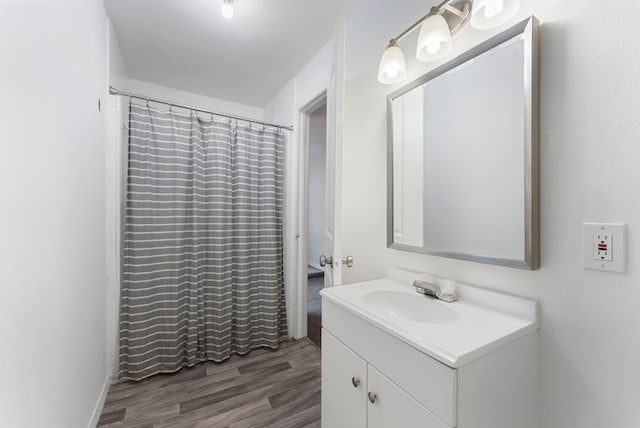 bathroom with a shower with shower curtain, wood finished floors, and vanity