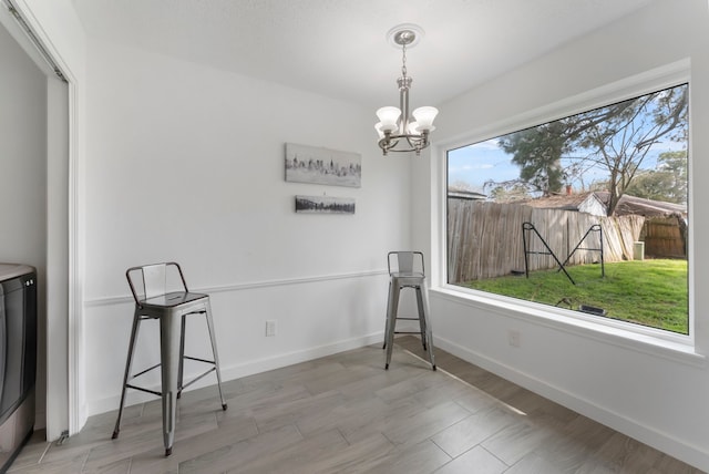 unfurnished dining area featuring baseboards, light wood finished floors, washer / clothes dryer, and an inviting chandelier