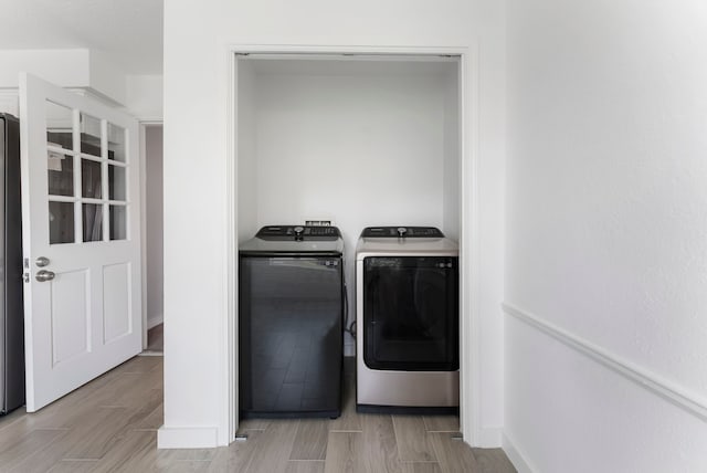 laundry area with wood tiled floor, laundry area, and washer and clothes dryer