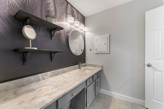 bathroom featuring wood finished floors, vanity, and baseboards