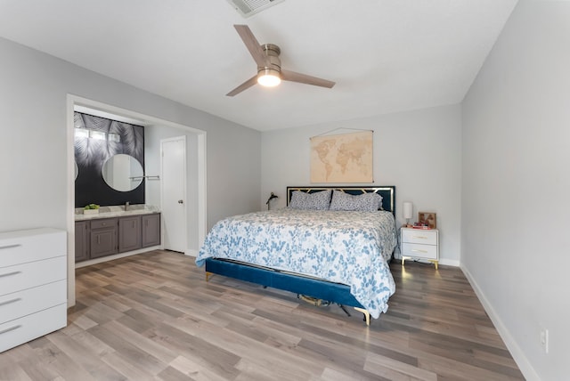 bedroom featuring a sink, visible vents, a ceiling fan, baseboards, and light wood-type flooring