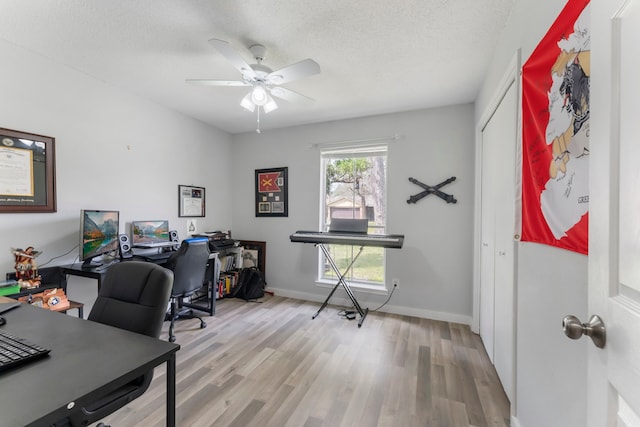 office area with a ceiling fan, baseboards, a textured ceiling, and light wood finished floors