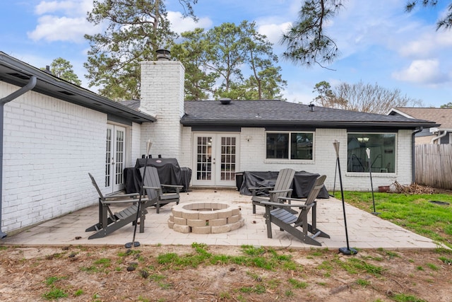 rear view of house with a patio area, french doors, brick siding, and a fire pit