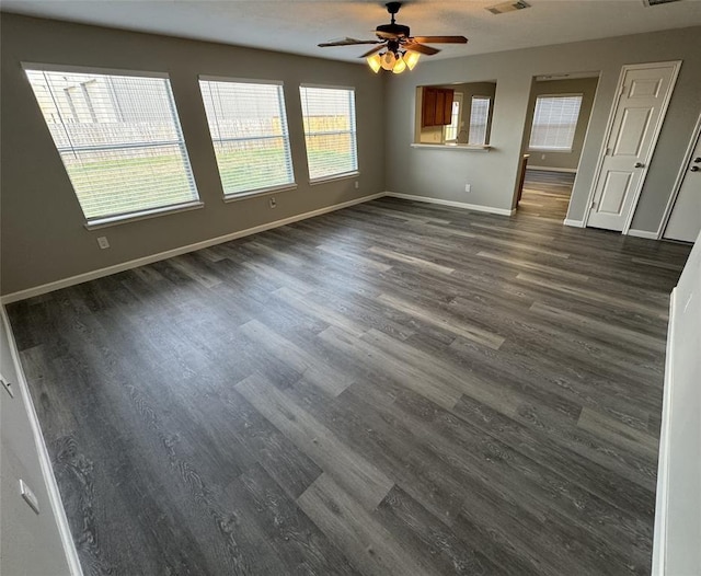 unfurnished living room with ceiling fan, baseboards, visible vents, and dark wood finished floors