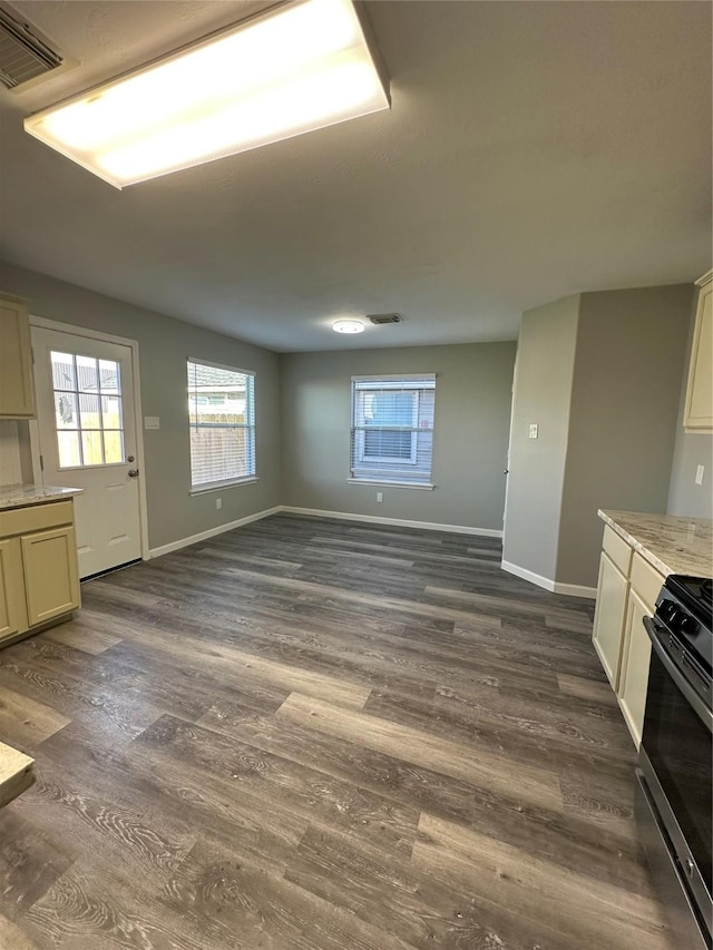 kitchen featuring baseboards, dark wood finished floors, visible vents, and range with gas stovetop