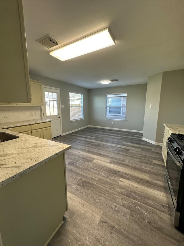 kitchen with gas range oven, visible vents, dark wood finished floors, and baseboards