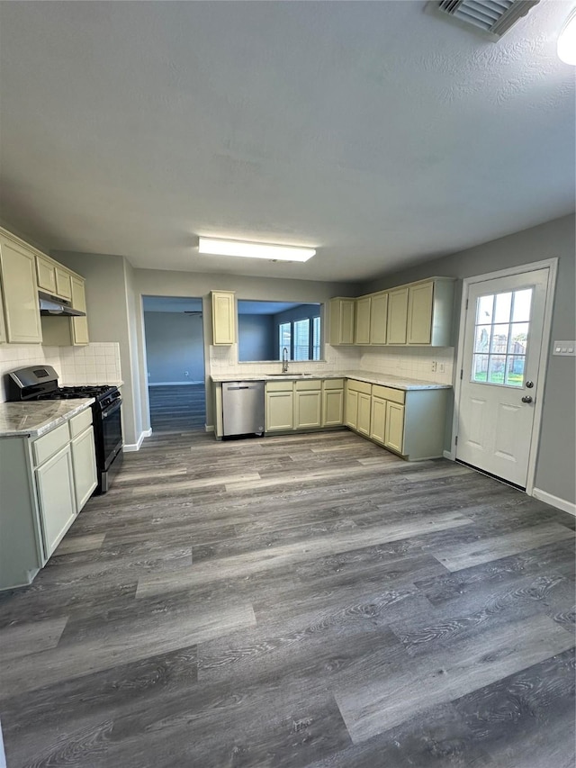 kitchen featuring dishwasher, dark wood-style floors, range with gas cooktop, and decorative backsplash