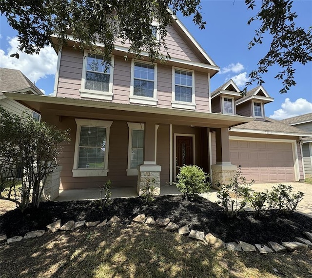 view of front of house featuring a garage, driveway, and a porch