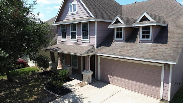 view of front of house featuring covered porch, driveway, and a shingled roof