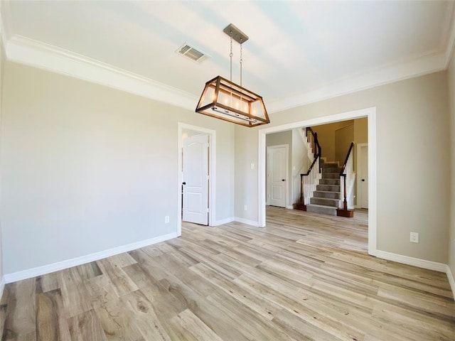 empty room featuring light wood finished floors, baseboards, visible vents, stairway, and crown molding