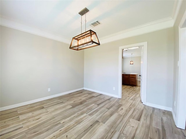 unfurnished room featuring light wood finished floors, baseboards, visible vents, and crown molding