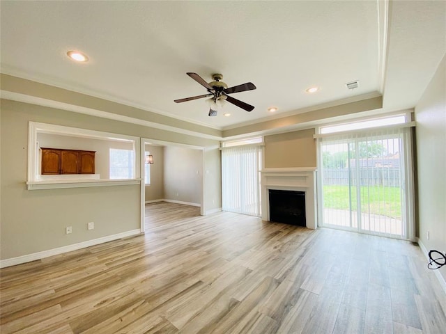 unfurnished living room featuring light wood-type flooring, baseboards, a fireplace, and ornamental molding