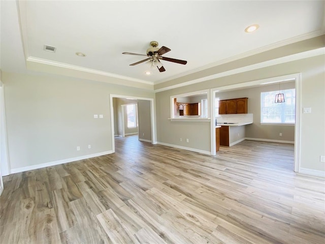 unfurnished living room with visible vents, crown molding, light wood-style flooring, and baseboards