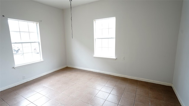 unfurnished room with tile patterned flooring and baseboards