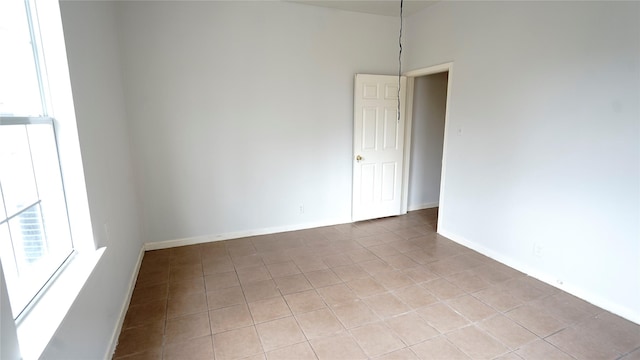 empty room with light tile patterned flooring and baseboards