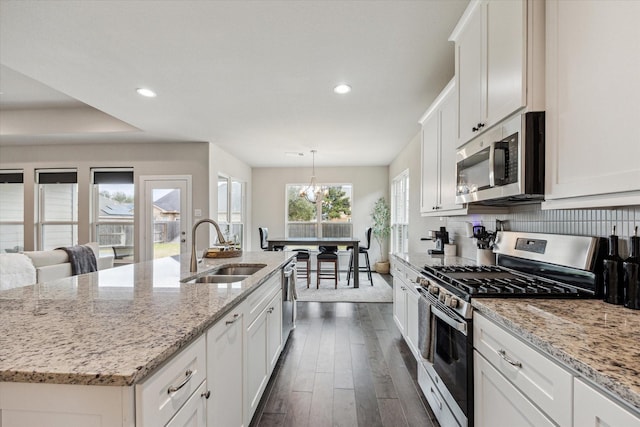 kitchen with dark wood-type flooring, white cabinetry, stainless steel appliances, and a sink