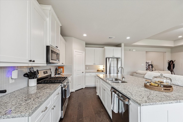 kitchen featuring white cabinetry, tasteful backsplash, appliances with stainless steel finishes, and a sink