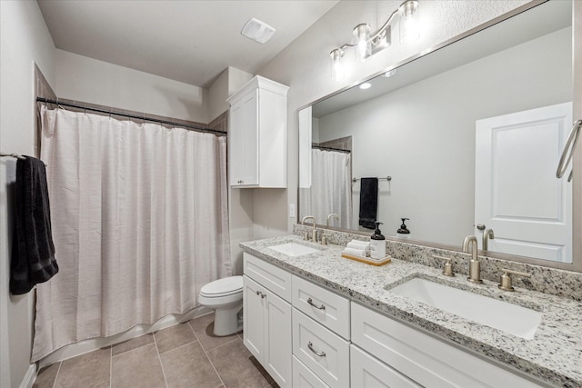 bathroom featuring double vanity, a sink, toilet, and tile patterned floors