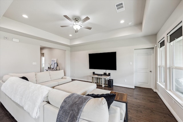 living room with dark wood-style floors, recessed lighting, a raised ceiling, visible vents, and baseboards