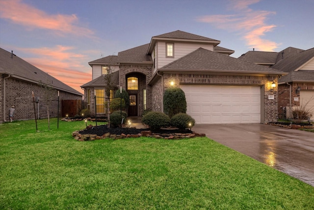 traditional home featuring brick siding, roof with shingles, a garage, driveway, and a front lawn