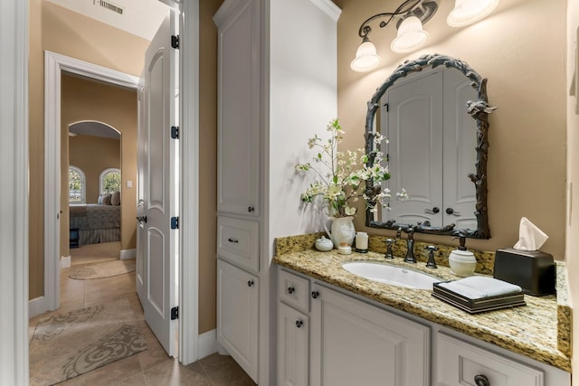 ensuite bathroom featuring visible vents, connected bathroom, vanity, and tile patterned floors