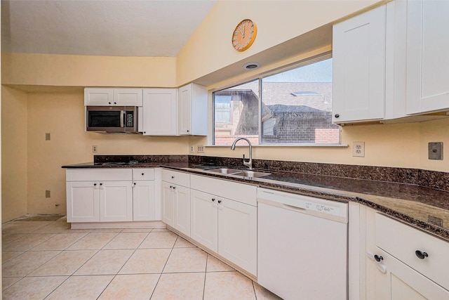 kitchen featuring stainless steel microwave, a sink, white cabinetry, and white dishwasher