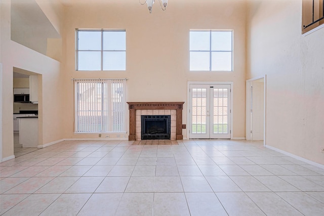 unfurnished living room featuring light tile patterned floors, baseboards, and a wealth of natural light