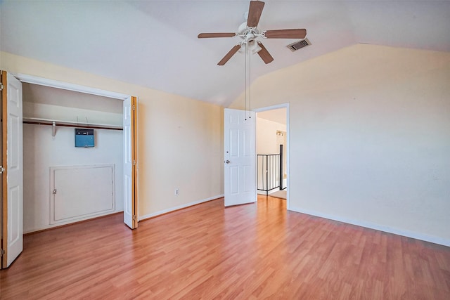 interior space featuring light wood-type flooring, visible vents, baseboards, and vaulted ceiling