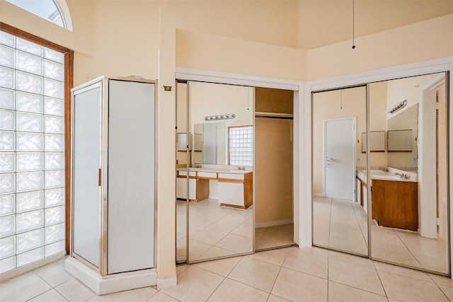 interior space featuring light tile patterned floors, multiple windows, and ensuite bathroom