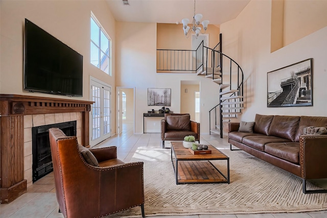 living room featuring stairway, light tile patterned floors, a high ceiling, and a chandelier