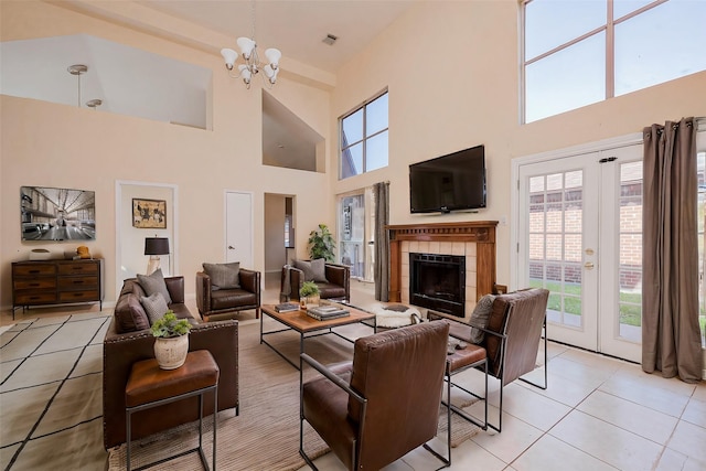 living area featuring a wealth of natural light, visible vents, a chandelier, and a fireplace