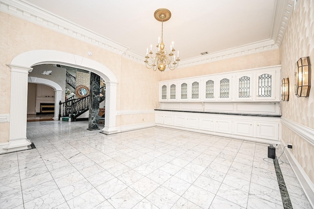 spare room with arched walkways, a wainscoted wall, stairway, ornamental molding, and marble finish floor