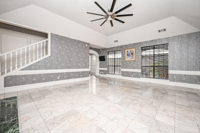 spare room featuring arched walkways, ceiling fan, visible vents, marble finish floor, and wallpapered walls