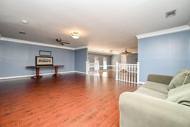 living room with ceiling fan, hardwood / wood-style floors, visible vents, and crown molding