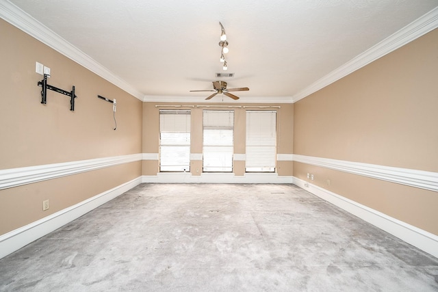 empty room featuring a ceiling fan, visible vents, crown molding, and baseboards