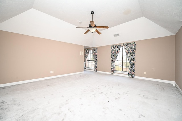 unfurnished room with lofted ceiling, light colored carpet, visible vents, a ceiling fan, and baseboards