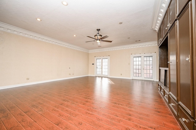 empty room with crown molding, wood finished floors, and french doors