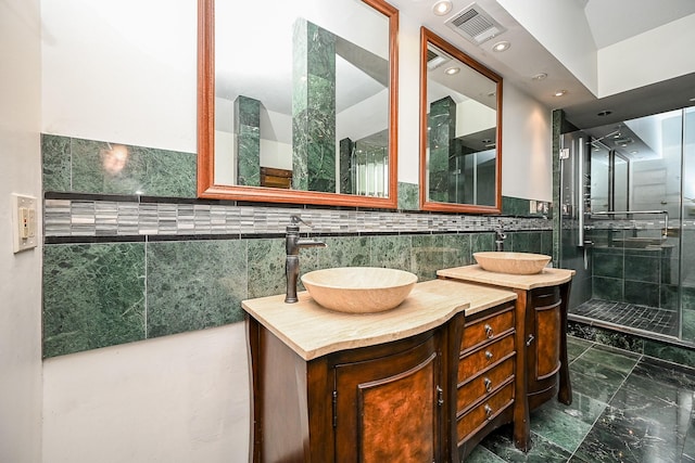 bathroom with visible vents, tiled shower, tile walls, and vanity